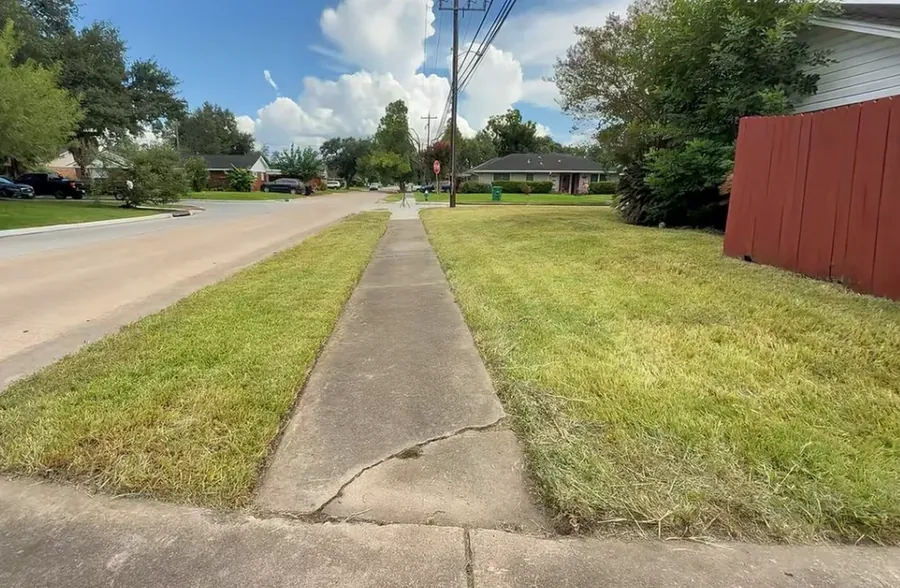 Freshly mowed lawn with defined edges along the driveway
