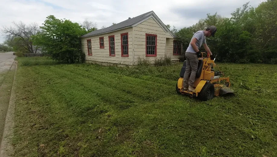 Crew member hauling away cleared shrub debris