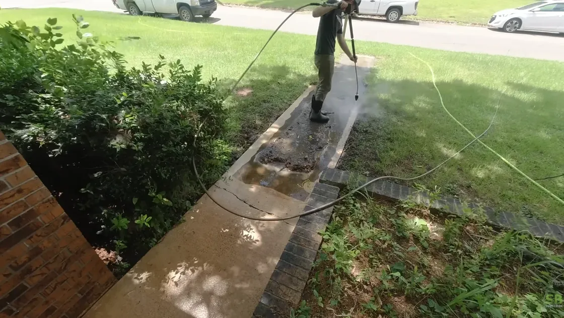 Two-person Aiken Lawn Pros crew edging and mowing a residential property