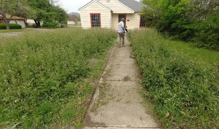 Technician operating a mower on a large residential lawn